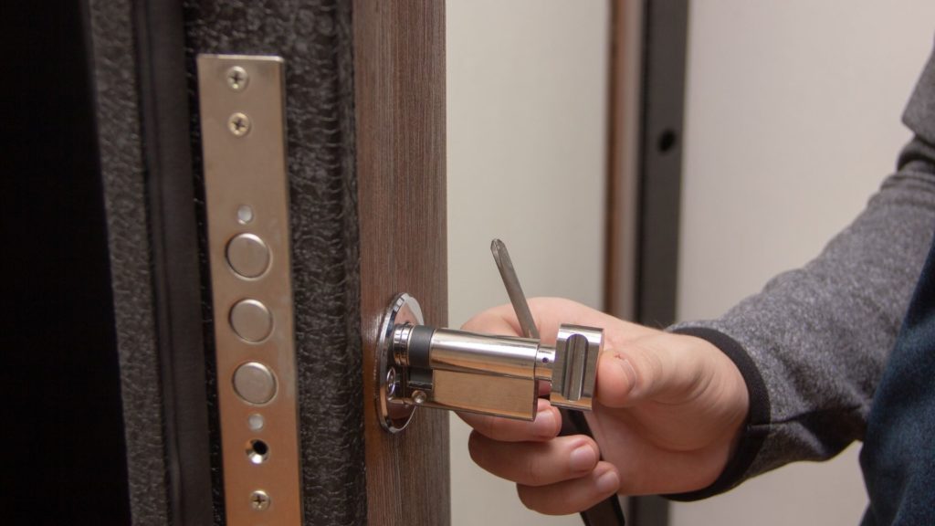 A commercial locksmith fixes a business's door
