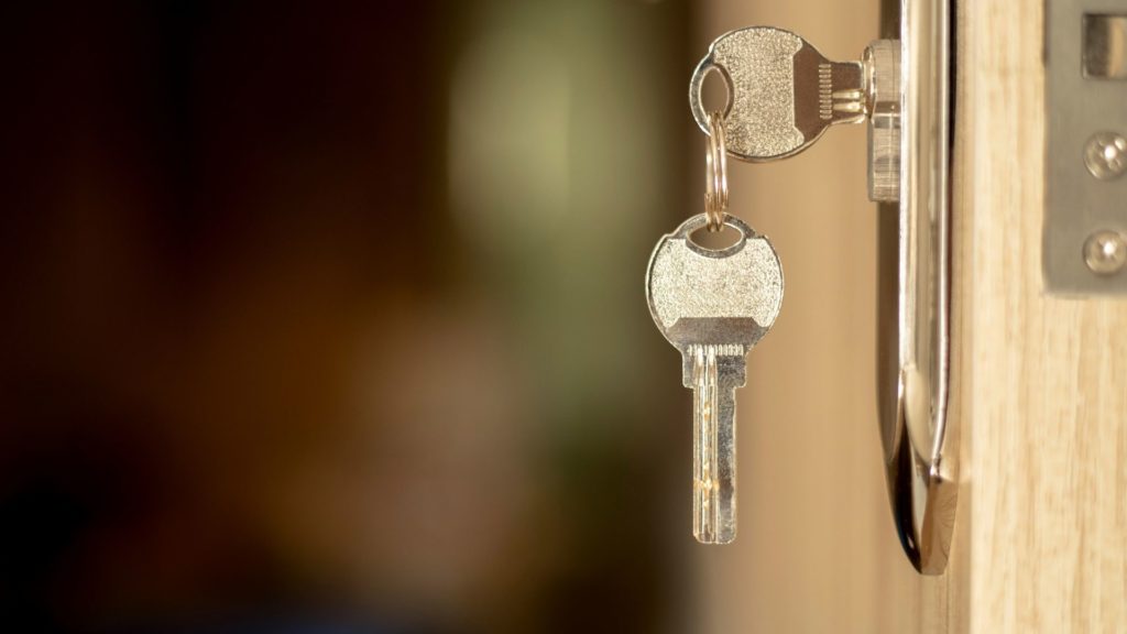 A commercial door lock with the keys hanging from it